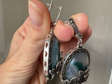 Elevate your style with our one of a kind silver jewelry featuring oval dangle earrings and a stunning combination of flower marcasite and oval moss agate in a beautiful green hue. This feminine and classic design is perfect for any occasion and makes for a unique addition to your jewelry collection. A timeless piece that any grandma will love.