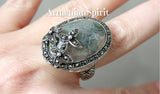 Expertly handcrafted in Armenian design, this sterling silver 925 ring features a large oval moss agate gemstone, accented with marcasite flowers. The big cabochon and vibrant green hue elevate any outfit, making it the perfect statement piece. Enjoy its timeless elegance and superior quality.