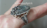 Indulge in this vintage Moss Agate ring, featuring a rare large oval cabochon gemstone in a gorgeous green hue. Crafted by skilled artisans in Armenia, this handmade ring is made of genuine Sterling Silver and adorned with delicate Marcasite flowers. A must-have for any jewelry lover and a retro addition to any collection.