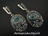 Expertly crafted from high-quality sterling silver 925, these handmade Armenian earrings feature striking moss agate stones in a rich green hue. The intricate flower design, accented with small marcasite stones, adds a touch of elegance to these very big earrings. With a secure English lock, these earrings are both stylish and functional.
