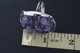 This extraordinary ring showcases a truly unique, one-of-a-kind amethyst drusy geode gemstone, a miniature cavern of sparkling purple crystals. Its organic shape and dramatic, raw beauty make it the undeniable centerpiece of the design. The gemstone, with its deep violet hues and captivating shimmer, is cradled within a setting of hand-crafted sterling silver 925, the cool metal providing a striking contrast to the gem's warmth. Each element of this ring, from the carefully sculpted silver.