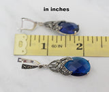 Teardrop blue topaz earrings with marcasite near a ruler showing 2 inch length.