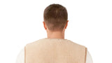 A man shown from the back wearing a beige knit sweater and sherpa teddy  vest over a white long-sleeve shirt and dark pants.