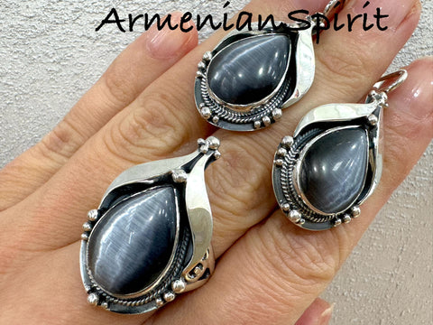 This jewelry set features a combination of gray tiger eye gemstones and sterling silver 925, offering a touch of elegance and sophistication to your wardrobe. Perfect for those who appreciate a retro and timeless style, this set includes both earrings and a ring for a complete and versatile look. Elevate your jewelry collection with this beautiful and unique set.

