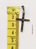 A small marcasite and silver cross near a yellow ruler 4 cm