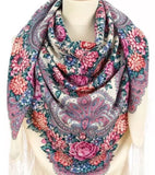 Floral and paisley patterned merino wool scarf in white pink and light blue on a mannequin with a white background