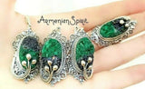 Set of malachite green gemstone earrings, ring and pendant with silver accents on a hand, branded 'Armenian Spirit'. The jewelry is one of a kind and it has artisan`s design. Made in Armenia at Armenian Spirit store.