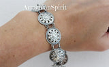 Silver bracelet with coin details on a wrist with 'ArmenianSpirit' branding.