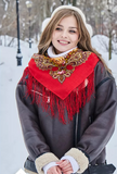 A woman wearing a beautiful Slavic ethnic shawl woven from 100% merino wool. The natural sheep wool features floral motifs set against a bold red background.