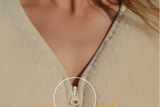 Close-up of a beige woolen beige zippered vest worn by a model, with a circular inset showing the zipper pull.