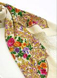 An oversized blanket-style palantine made of premium ivory merino wool, showcasing warm and bright yellow, pink, and orange flower arrangements.