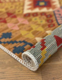 Roll of patterned Armenian rug on a wooden floor