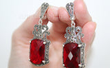 Long Tudor-style dome earrings with central red stones and intricate marcasite detailing, handcrafted by Armenian Spirit.