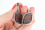 Step outside the box and make a bold statement with our handmade Armenian silver earrings. Crafted with tiger's eye gemstones, these unique earrings are perfect for the risk-takers and adventurers. Each piece is a one-of-a-kind artisan creation from Armenia. Embrace the challenge and add a touch of adventure to your wardrobe.
