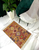 Decorative Armenian rug with geometric pattern on a white floor next to a chair and plant.
