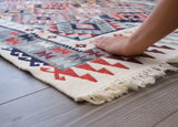 Person stepping onto a patterned rug with colorful geometric design