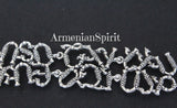 Armenian Spirit wide silver alphabet bracelet displaying traditional cultural lettering, worn on a black back background to showcase its bold statement design and Armenian Spirit jewelry brand title.