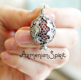 A sterling silver 925 pendant necklace with a pomegranate design, featuring faceted garnet stones.