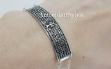 A sterling silver men's bracelet with Armenian prayer and khachkar cross text, displayed on a person's wrist with a title Armenian Spirit.