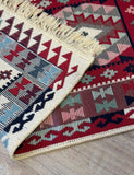 Close-up of a patterned rug with geometric designs on a wooden floor.