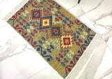 Decorative Armenian rug with geometric red and green pattern on a tiled floor