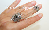 Double ring on woman finger made of sterling silver and adorned with small black stone and traditional Armenian ornaments under a brand Armenian Spirit.