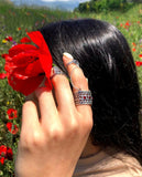A woman wearing 2 Armenian taraz rings on the poppy flowers field.