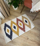 Decorative Armenian rug white with geometric blue and red pattern on a wooden floor
