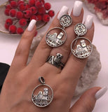 Hand wearing silver earrings, pendant and ring with a Artsakh symbol Babo and dedo and Artsakh engraving on a traditional Armenian carpet decorative background
