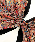 Colorful paisley patterned large palantine shawl tied in a knot on a white background