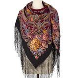 Colorful floral Slavic patterned oversized blanket scarf with fringes on a mannequin against a white background
