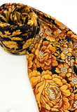 Floral patterned shawl with black background with large yeallow and orange flowers on a white background