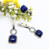 A set of sterling silver jewelry featuring lapis lazuli gemstones, including dangle earrings and a ring, with gold-plated accents.