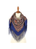 Blue women`s scarf with pattern and silky  fringes on a mannequin against a white background