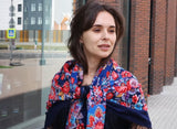 A woman wrapped in this vintage floral merino wool shawl carries history on her shoulders. The oversized design offers warmth and drama, while the rich blue and red flowers celebrate Slavic folk aesthetics. A true heirloom piece for lovers of authenticity.
