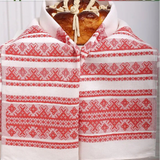 A white and red patterned embroidered towel cover draped over  the bread and salt.