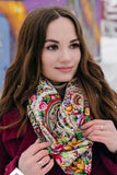 Beautiful woman with floral shawl which made of natural merino wool with pink and yellow flowers. The woman is in wine red coat which matches wither shawl.