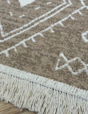 Close-up of a textured rug with geometric pattern and fringe details