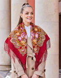 A woman wearing a beautiful Slavic red shawl made of 100% merino wool. The natural sheep wool is fringed and decorated with yellow and pink peony flowers.