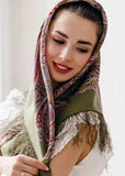 Buy a woolen head shawl in khaki and beige with elegant fringe. A woman wears it gracefully, enjoying its warm, non-prickly softness.