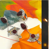 A set of sterling silver Armenian jewelry featuring gold plated parts and natural brown carnelian gemstones, displayed on a white surface with a blue background.