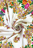 An oversized blanket-style palantine made of premium ivory merino wool, showcasing warm and bright yellow, pink, and orange flower arrangements.