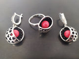 A set of sterling silver 925 jewelry, including a small ring and a pair of earrings with round lab coral, displayed on a dark background.
