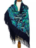Navy blue natural merino wool warm large scarf with green floral patterns and tassels on a mannequin.