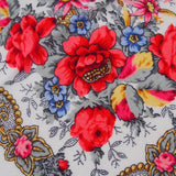 Floral patterned Slavic shawl with red flowers and colorful accents on a gray background