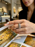 Person holding a book with a detailed illustration, wearing modern Armenian ring.