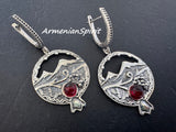 Silver pomegranate  earrings with Armenian ornaments, grape pattern and  red gemstones on a dark background, branded 'Armenian Spirit'.