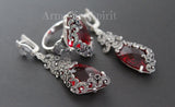 A set of red crystal triangular earrings and ring, with intricate silver designs and embellishments.