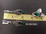Earrings and ring green stone near red ruler in inches