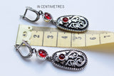 Armenian earrings with English lock, taraz wthnic ornaments in herbal style and garnet red in the diddle near the ruler which shows 5 cm 
